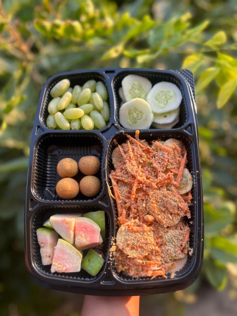 Bento with grapes, cucumber, guava, and a fresh salad